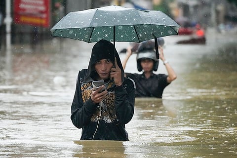Philippines Tropical Storm Yagi: A resident wades along a flooded street